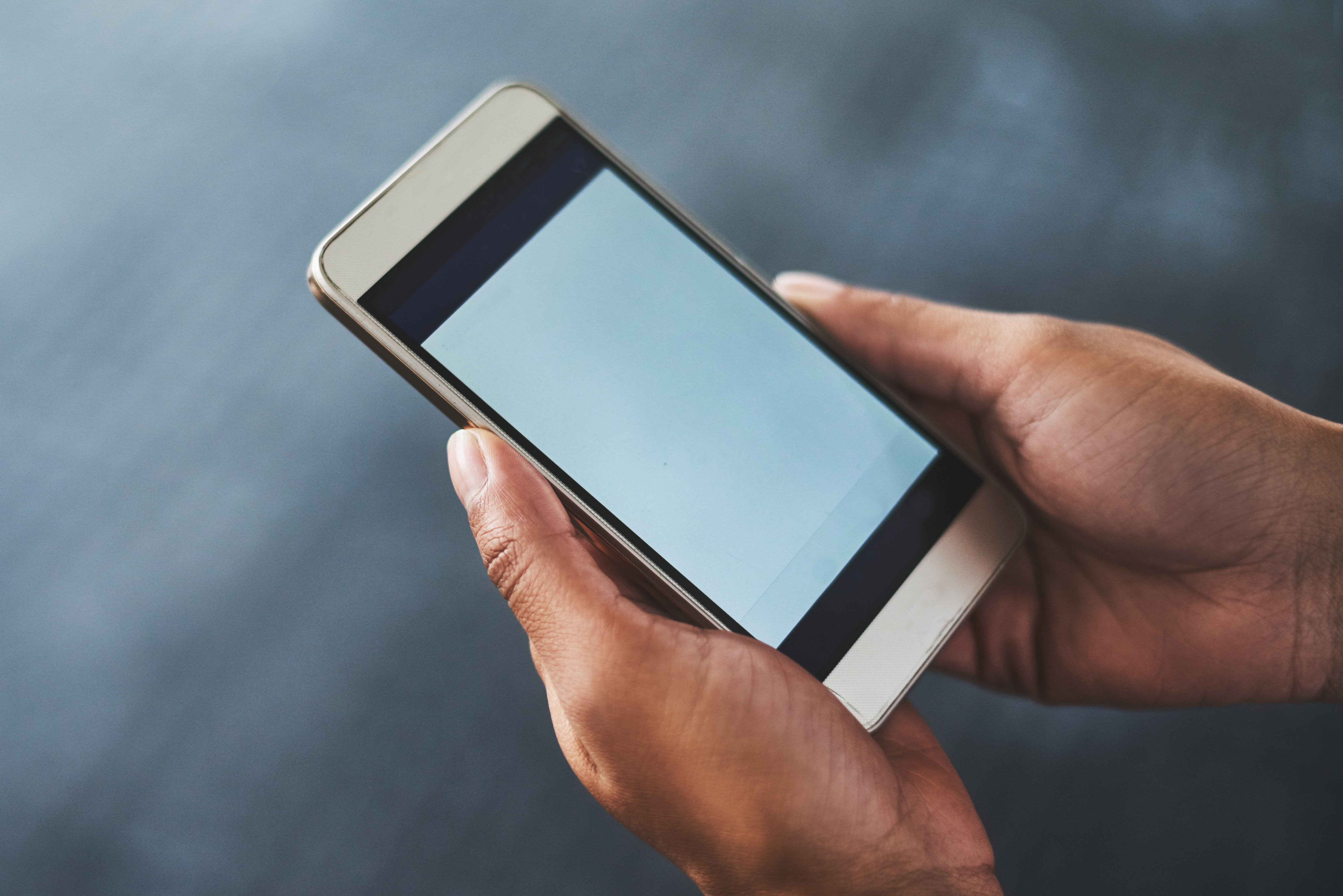 Cropped shot of a woman using a smartphone in a gym